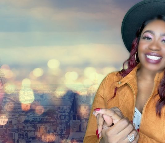 A person smiling with a city in the background Description automatically generated with medium confidence